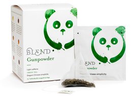 Green tea in a pyramid-shaped box with a panda design. The tea is loose leaf and has a natural, earthy aroma.