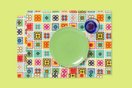 Colorful patterned placemats, designed and made in Barcelona, featuring a round green plate or platter in the center.