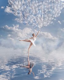 A graceful ballerina dancer floating on water, surrounded by a cloud of white balloons against a blue sky. This serene and ethereal image would make a beautiful poster for a ballet or dance studio.