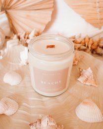 Cream colored scented candle with wooden wick, beach-inspired aesthetic, coastal home decor fragrance.