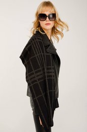 Black and grey plaid scarf made of soft, warm material. Rectangular shape with fringed edges. Suitable for casual or formal wear.