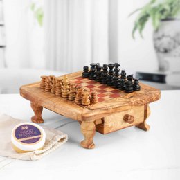Handmade olive wood chess set with red squares, storage drawers, natural wood grain, elevated board game.