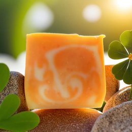 Vegan orange-scented shower butter with a creamy, moisturizing formula for dry skin. Features an orange slice and green leaves for a natural, refreshing look.