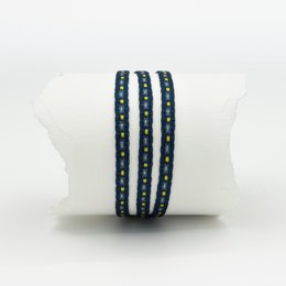 A triple-strand bracelet with navy blue and white beads, featuring a clasp closure.