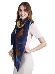  A long, rectangular scarf made of fine, sustainable wool in a vibrant blue, orange, and yellow abstract print pattern. The scarf has a soft, luxurious feel and is suitable for casual or formal wear.