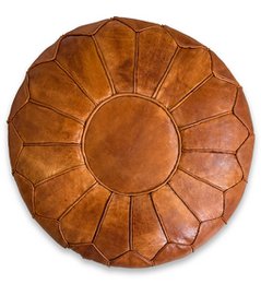 Large round cognac brown leather pouf ottoman with a sunburst pattern design.