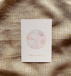 A greeting card with a simple watercolor illustration of a moon and the text "Hurrah" printed on it. The card appears to be part of a baby or children's card collection.
