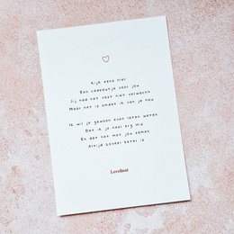 A white greeting card with a handwritten love poem and a small heart symbol. The card appears to be for a Valentine's Day or romantic occasion.