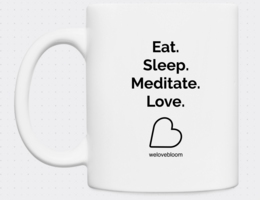 A white ceramic mug with the text "Eat. Sleep. Meditate. Love." and a heart icon printed on it. The mug appears to be a simple, minimalist design.