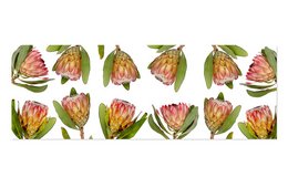 A table runner featuring a protea duo design. The runner has a vibrant floral pattern with pink and green protea flowers against a light background.