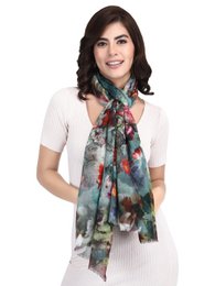  Colorful floral print scarf made of fine, sustainable wool. Features a mix of vibrant flowers and abstract patterns. Soft, lightweight material perfect for adding a touch of style to any outfit.