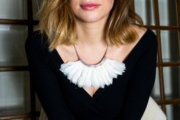 A white and black charm necklace with a feathered design.