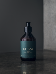 A dark green bottle with a black pump dispenser, labeled "DETZA". This hand sanitizer product is designed to be anti-bacterial and effective for hand cleansing.