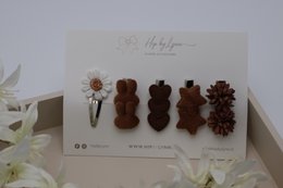  Hair clips in gold and silver colors, featuring various decorative shapes and textures including bows, flowers, and geometric designs.