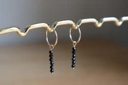 Elegant gold-filled hoop earrings with black spinel beads, perfect for adding a touch of sophistication to any outfit.