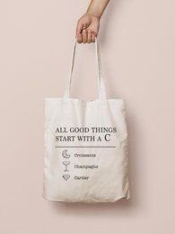 A white tote bag with the text "All good things start with a C" printed on it. The bag appears to be made of a durable, canvas-like material and has a simple, minimalist design.