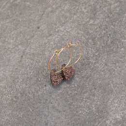  Hoop earrings with chocolate-colored heart charms. The earrings feature a round gold hoop with a heart-shaped charm that has a glittery, textured surface.