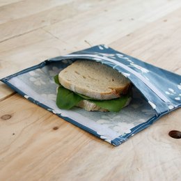 Snack pouch made of durable, reusable material with floral pattern. Suitable for storing sandwiches, snacks, or other small food items.