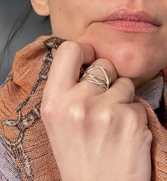  Large silver statement ring with intricate twisted design.