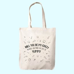 A cotton tote bag with the text "Will you be my chef?" printed on it. The bag features a simple, minimalist design with various cooking-related icons like a whisk, spoon, and heart shapes. This reusable shopping bag is perfect for the home chef or food enthusiast.