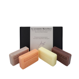 Assorted handmade soap bars in various scents including melon, cotton flower, vanilla, and mimosa. Rectangular shaped bars in pastel colors.