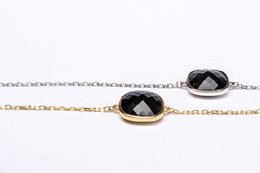 Silver and gold charm bracelets with a cushion-cut zirconia stone.