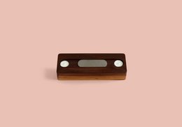 Walnut wood storage basket with rectangular shape and two cutouts on the sides.