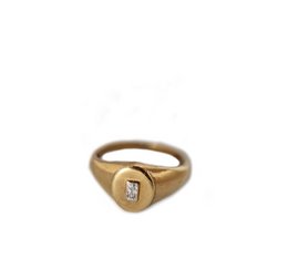 A gold statement ring with a single diamond-shaped accent stone.