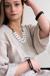 A white beaded necklace with a metal chain. The necklace has a simple, elegant design and appears to be suitable for casual or formal wear.
