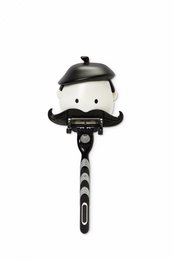 A black and white razor holder with a mustache design, suitable for shaving sets.