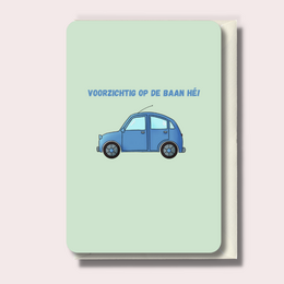 Blue car illustration with Dutch text "Voorzichtig op de baan hè!" (Be careful on the road!)
colors: blue, green
style: simple, cartoon-like illustration
shape: rectangular card with rounded corners
