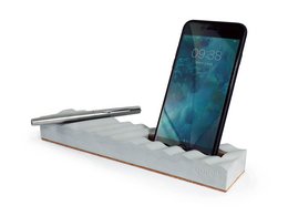 Concrete phone and pen stand in a modern, minimalist design. Features a sleek, rectangular shape with a textured surface and a slot to hold a smartphone or pen.