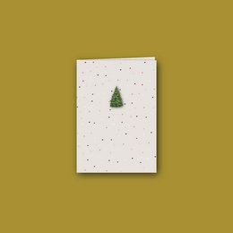 Folded Christmas card with a green Christmas tree and white background with gold dots.