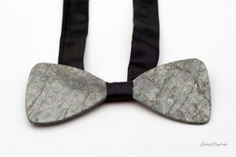 A green, textured bow tie made of a natural material, likely stone or marble, with a sleek, modern design.