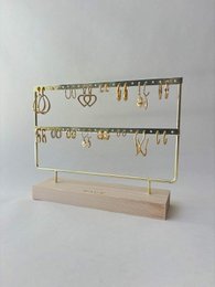 Gold jewelry organizer stand with two tiers, wooden base, heart and moon charms display.
