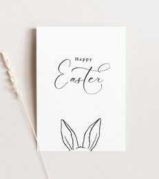 A minimalist Easter card featuring the text "Happy Easter" and the outline of a pair of bunny ears. The card is A6 size.