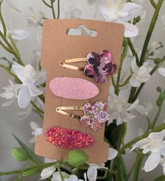 Set of 69 colorful hair clips for kids, featuring floral and heart-shaped designs in various shades of pink and purple.