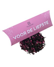 Loose leaf tea in a pink package labeled "Voor de liefste" (For the dearest). The tea appears to be a blend of black tea leaves and dried rose petals, creating a vibrant purple-red color.
