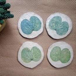 "Round papier-mache coasters with kachnar leaf design in blue and green botanical print"