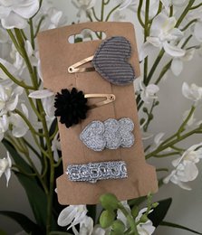  Set of 88 hair clips for kids, featuring a variety of styles including a black flower clip, a silver glitter clip, and a rhinestone-embellished clip.