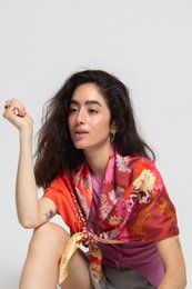 Vibrant patterned scarf in shades of red, orange, and yellow with a leopard print design. Made of 100% recycled polyester twill fabric, measuring 180 cm x 114 cm.