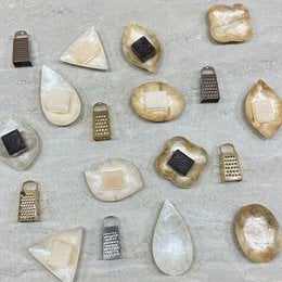 Gift set with white and gold gift bags, product information cards in multiple languages, and various grater accessories.