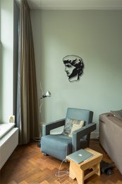 Metal wall art featuring a sculptural profile of a human face in a modern, minimalist style.