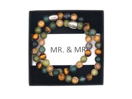 A set of two bracelets featuring a mix of colorful beads in a variety of shapes and sizes, including round, oval, and irregular shapes. The beads appear to be made of natural materials like stone or wood, with a range of earthy tones including greens, browns, and grays.