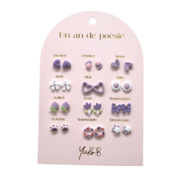 Set of 12 pairs of nickel-free ceramic earrings in various purple floral and geometric designs.