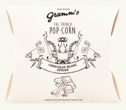Caramel popcorn coated in white chocolate and spices, 30g pack. Sweet and savory snack.