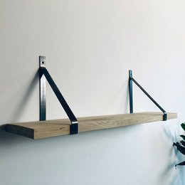  A natural wood book stand with a triangular design and black metal brackets.
