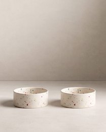 Two round, speckled pet food bowls in white color. Suitable for serving pet food or treats.