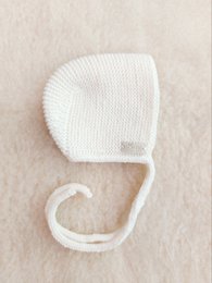 Soft, cozy merino wool bonnet in a natural color. Features a classic design with a tie-up closure to keep baby's head warm and protected.