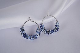  Beaded hoop earrings in blue tones, featuring a circular hoop design with clusters of small blue beads arranged in a decorative pattern.